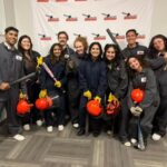 Group of participants in safety gear holding various tools, ready for a splatter room experience at All Out Smash in Denver.