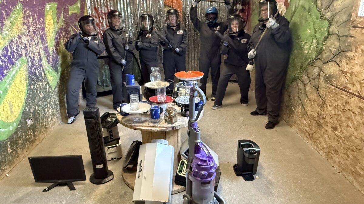 Group of friends smashing items in a rage room at All Out Smash in Denver - one of the most unique things to do in Denver