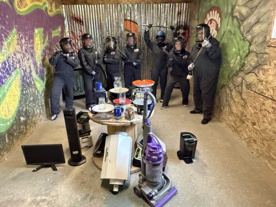 Group of friends smashing items in a rage room at All Out Smash in Denver - one of the most unique things to do in Denver